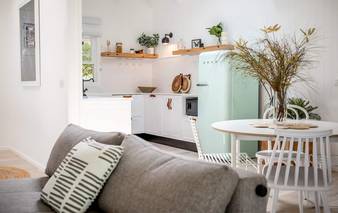 Interior of a bright cottage, looking into the kitchen.