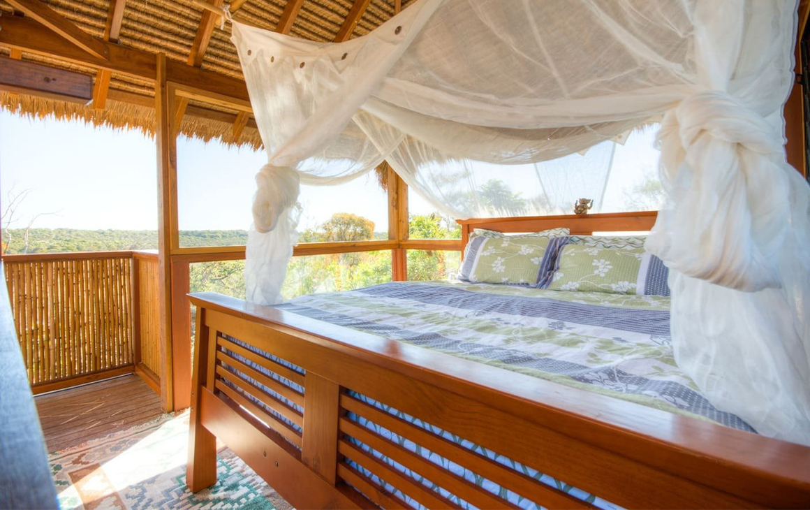 A canopied bed in a tree-house style cabin.