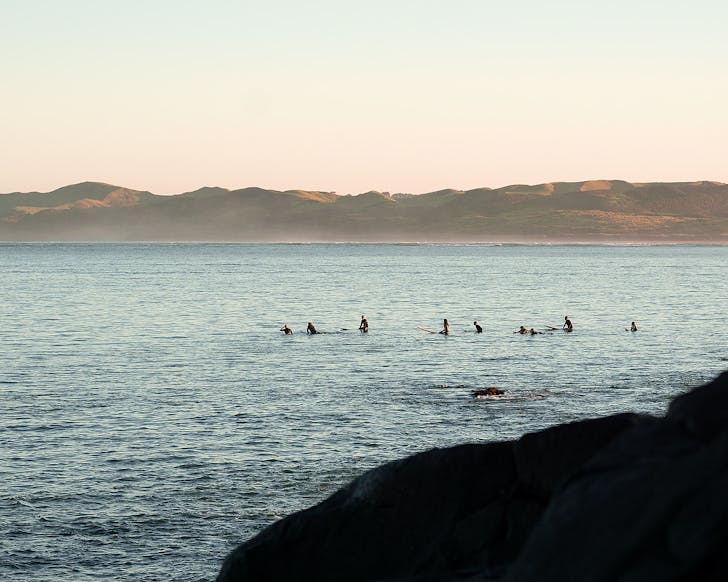 Surfers wait for a break at Manu Bay in Raglan.