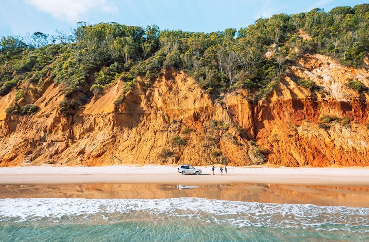 The Coloured Sands is an orange-coloured cliff face that runs along the beach near Rainbow Beach.