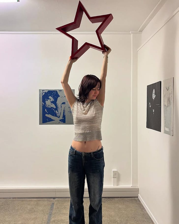 Raisa Mclean holds up a red starâone of her latest worksâin the RM Gallery, pre-exhibition.