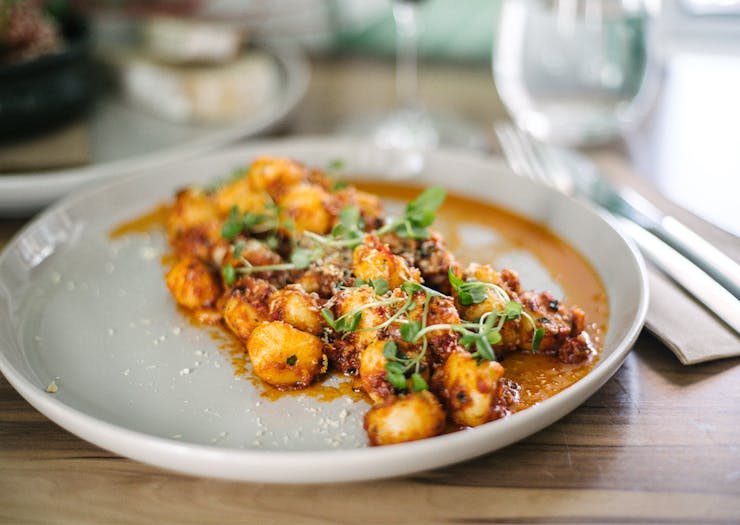 a plate of gnocchi in a tomato based sauce