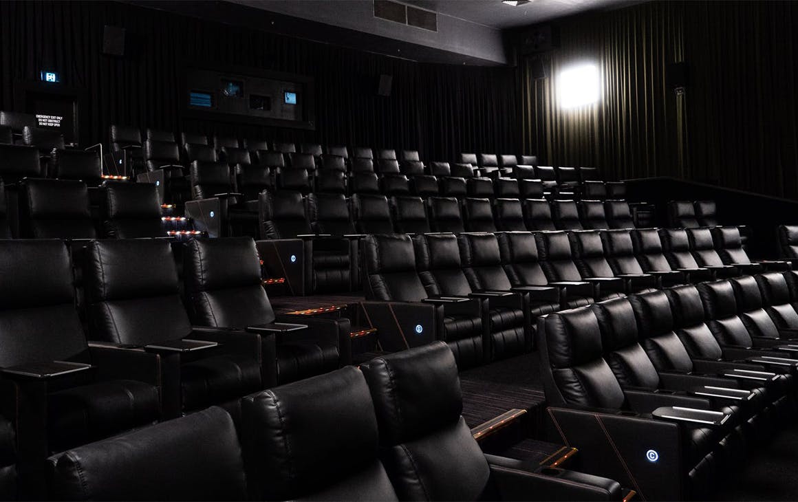 a dark cinema lined with reclining chairs