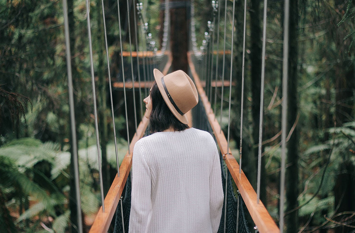 A girl walks amongst the Redwoods in Rotorua.