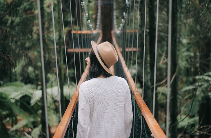 A girl walks amongst the Redwoods in Rotorua.