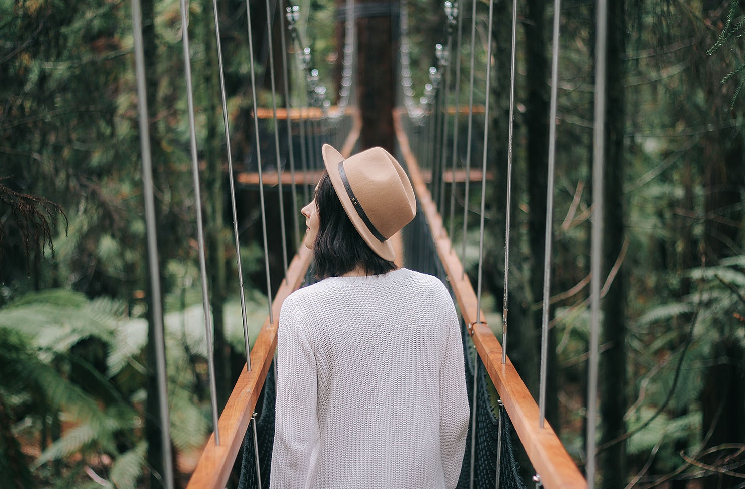A girl walks amongst the Redwoods in Rotorua.