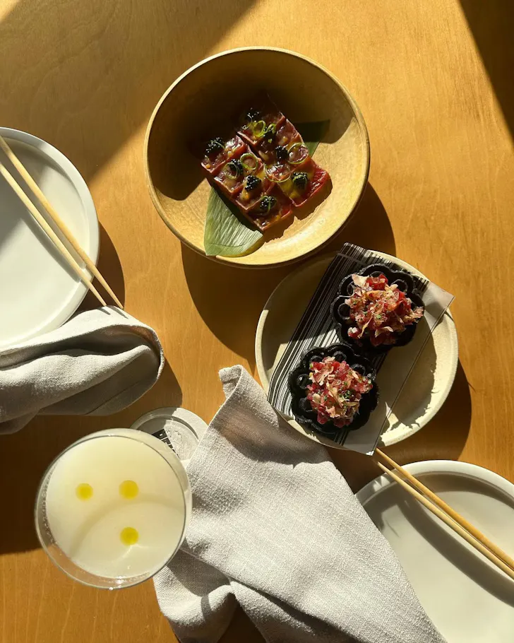 Three dishes on a wooden table at Rekodo in Barangaroo