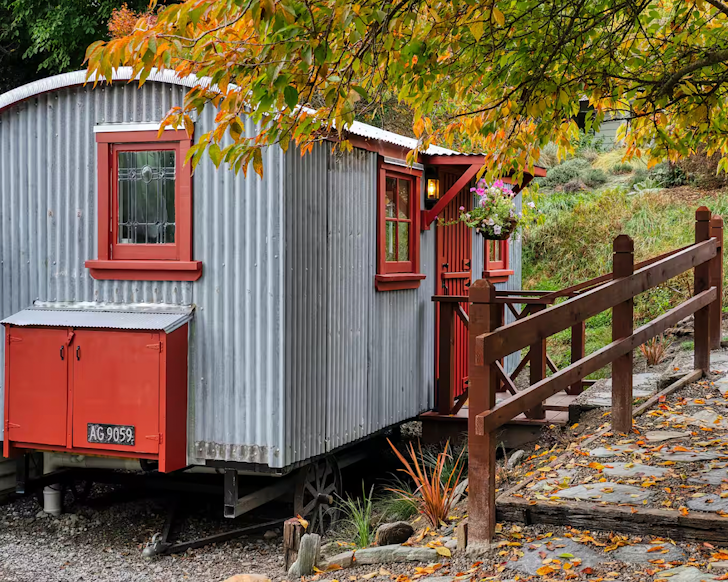The corrugated iron and red exterior of Henrietta's Hut one of the best Queenstown Airbnbs