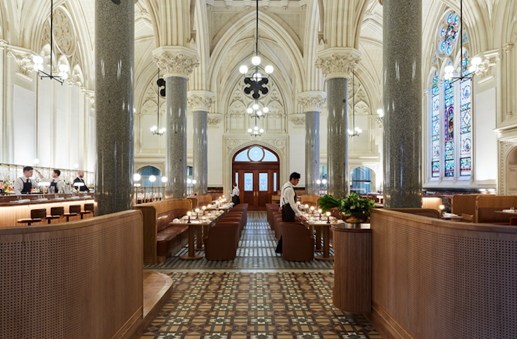 A large dining hall with a stain glass window, one of the best restaurants in Melbourne. 