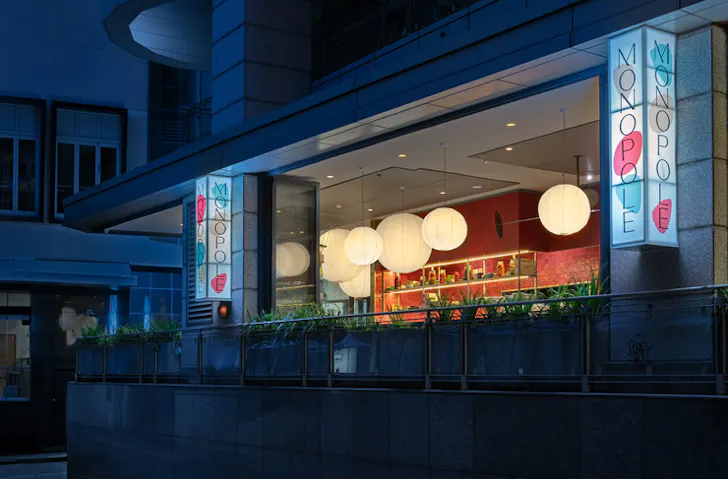 The front facade of Monopole restaurant at night