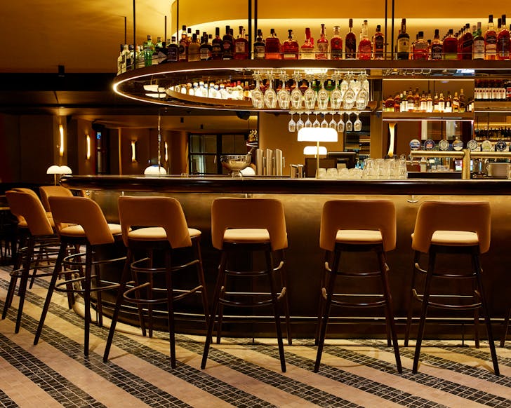 The glowing golden bar at Menzies, one of the best restaurants with live music in Sydney