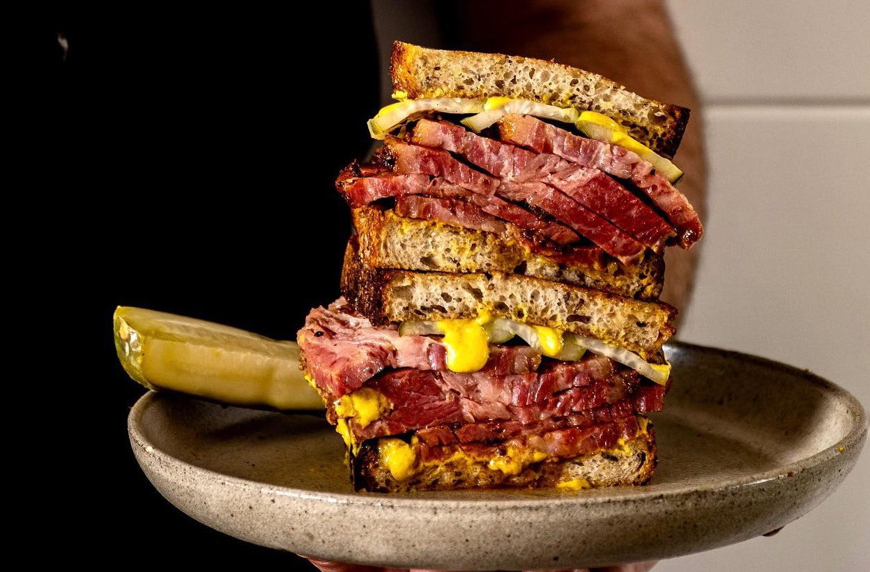 A Reuben sandwich served on a ceramic plate 