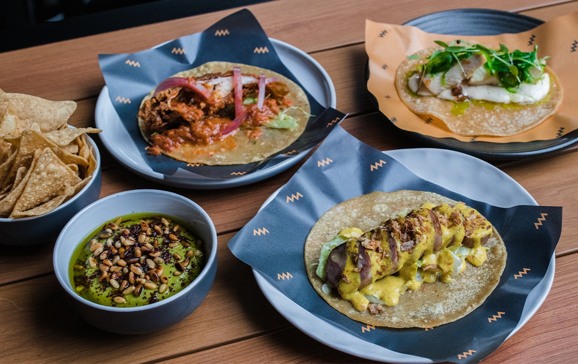 several plates of tacos and chips