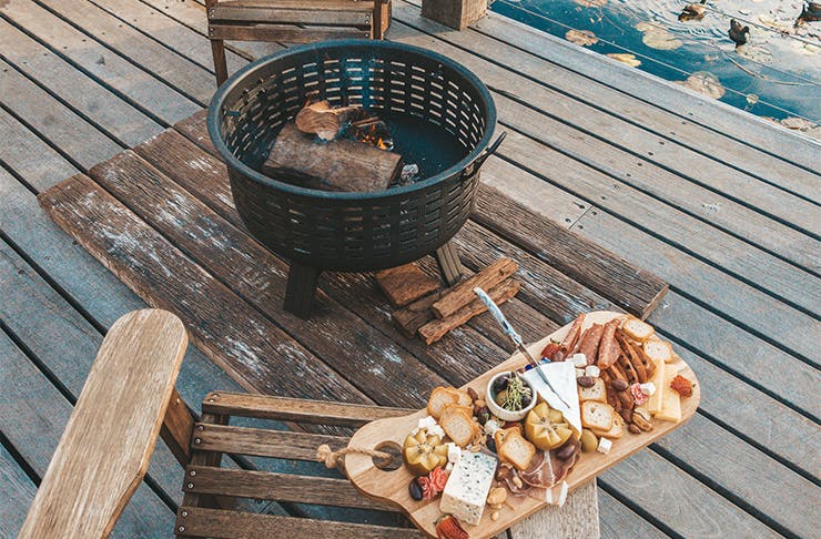 a fire pit with a cheeseboard