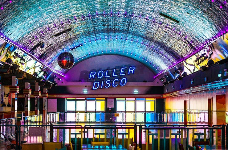 A view of a roller disco with bright neon lights.