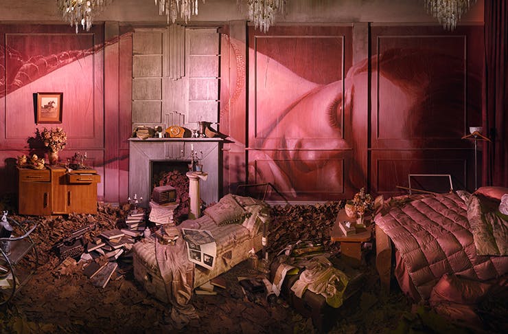 A pink room covered in work from artist Rone.