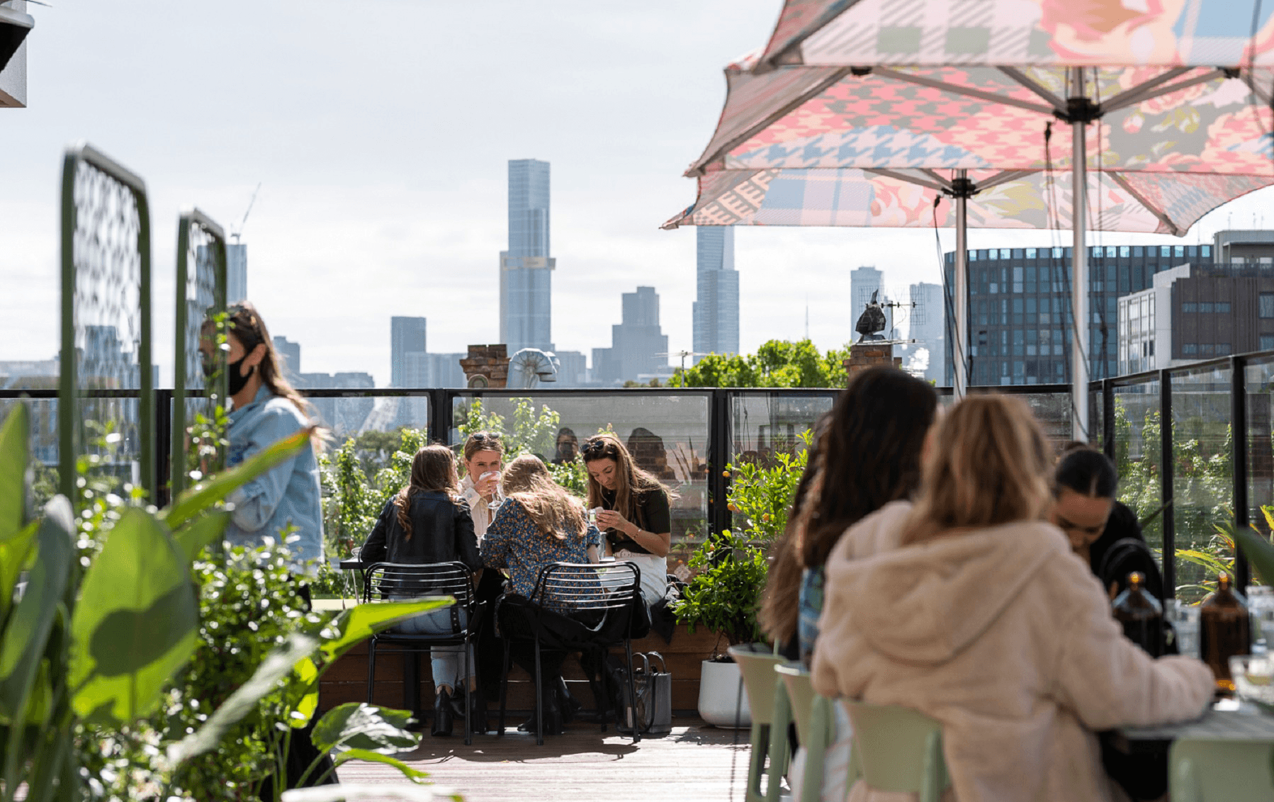 A best rooftop bar in Melbourne with the sun shining and people drinking.