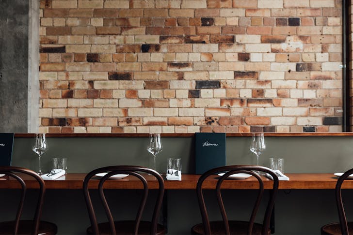 bar seating in front of a brick wall