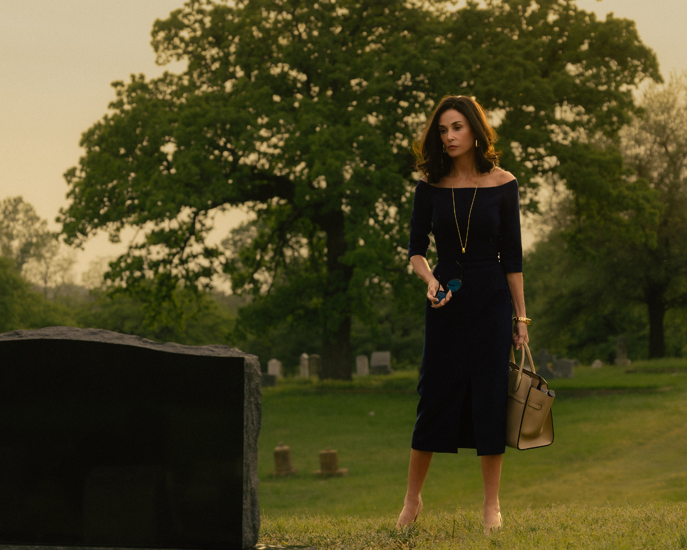 Person standing in front of grave.