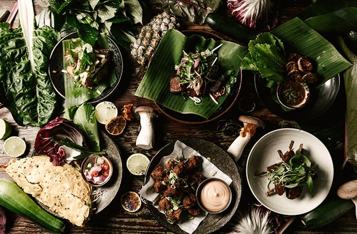 Several earthy vegan dishes spread out on a table.
