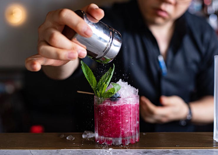 A bright pink cocktail being prepared at Ruse. 