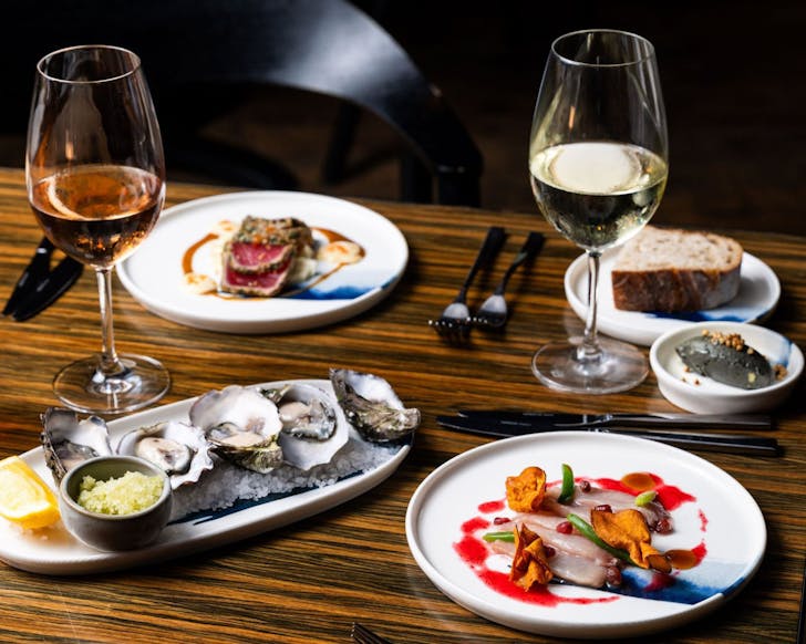 A spread of seafood dishes and wine at sailmaker restaurant