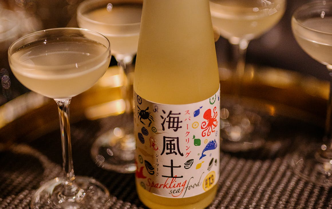 a bottle of sake with coup glasses