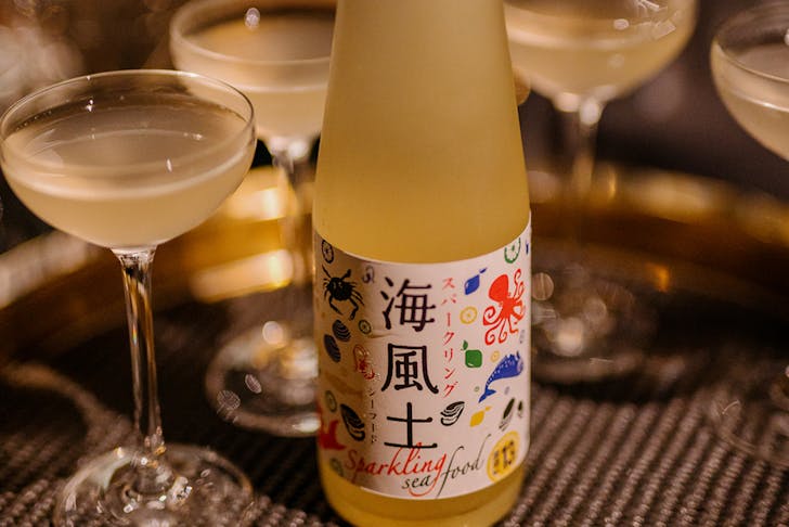 a bottle of sake with coup glasses