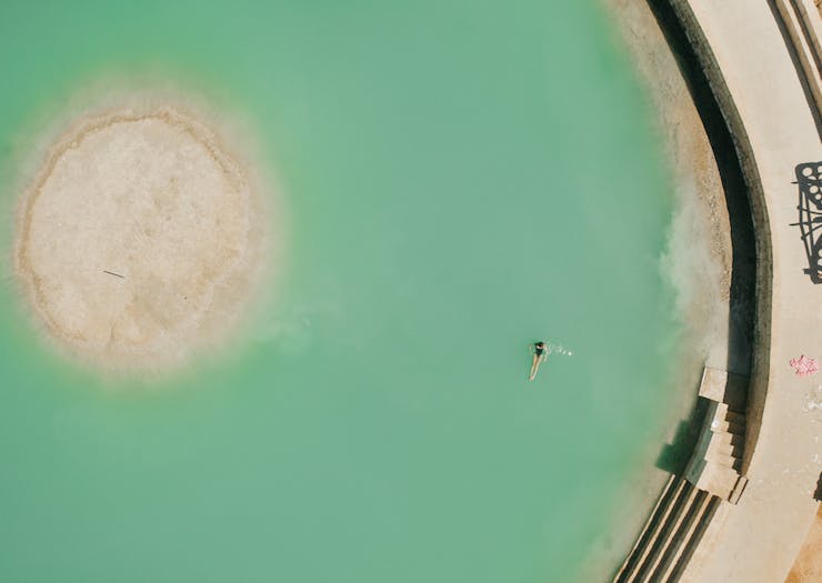 a person swimming in the saltwater pool near Wave Rock
