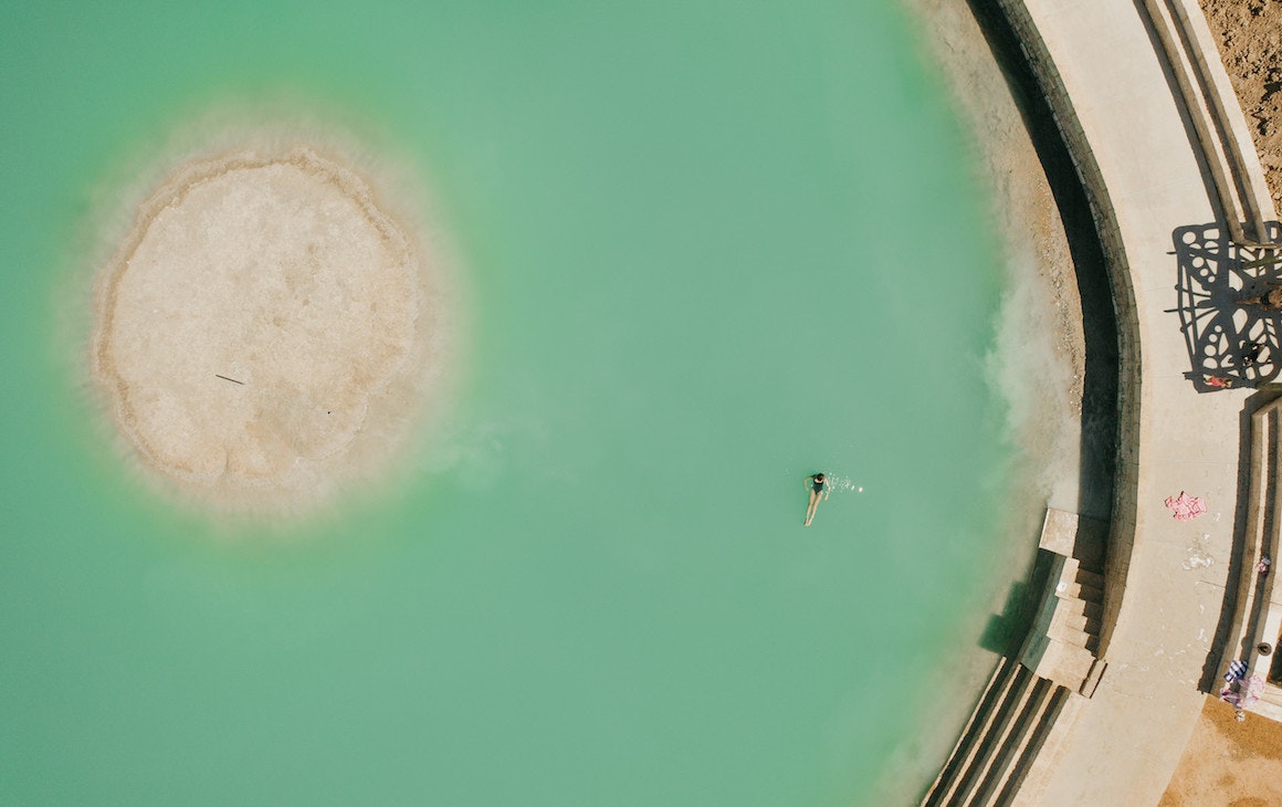 a person swimming in the saltwater pool near Wave Rock