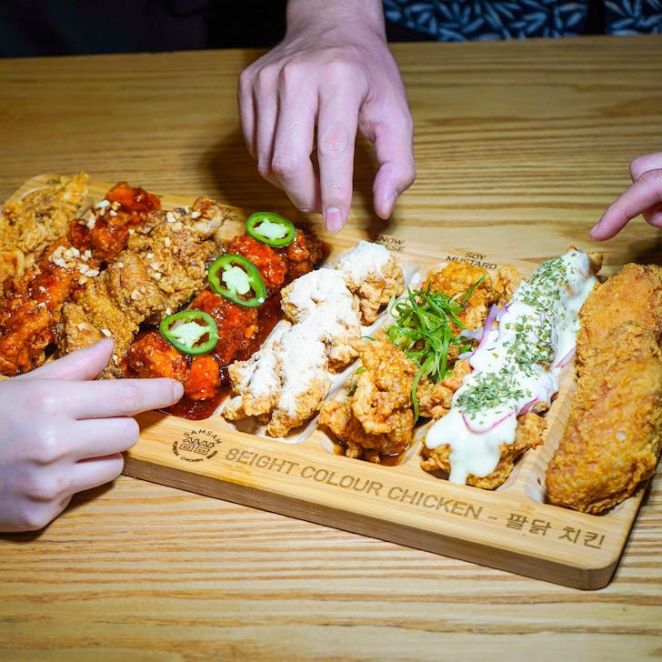 two hands picking up chicken
