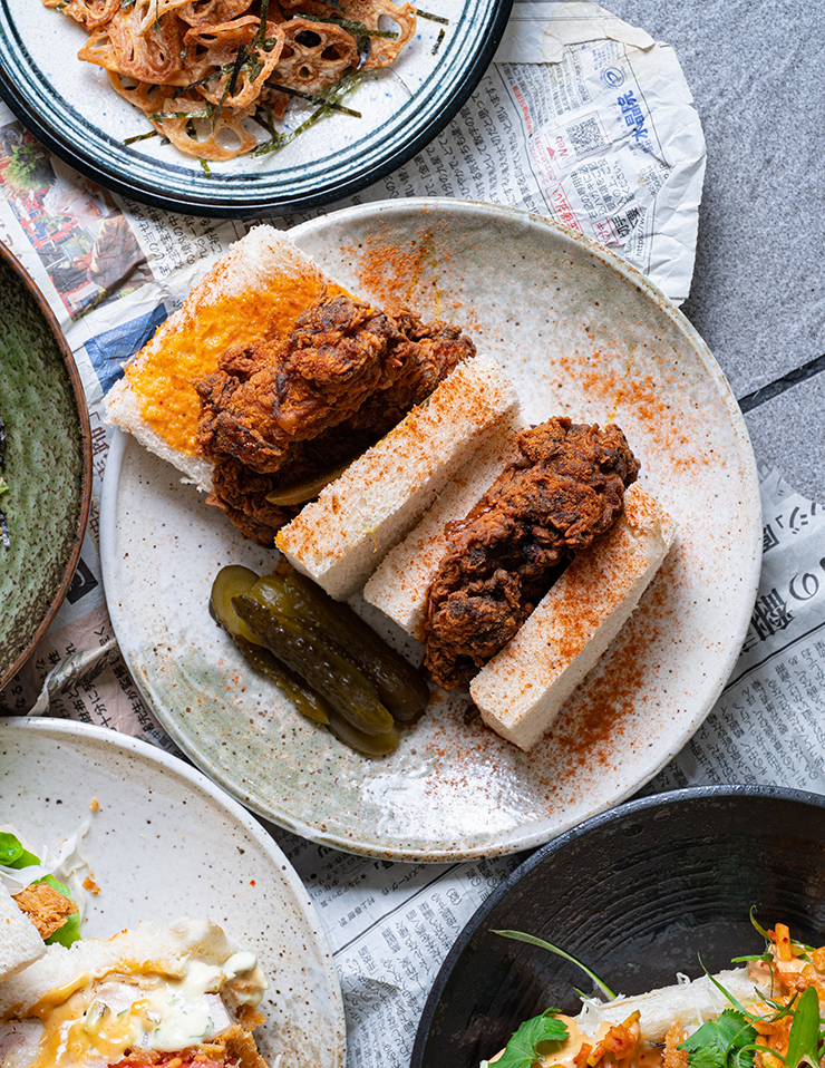 A fried chicken sando covered in spices.