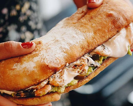 An extra large sandwich dripping with mayonnaise.