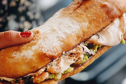 An extra large sandwich dripping with mayonnaise.