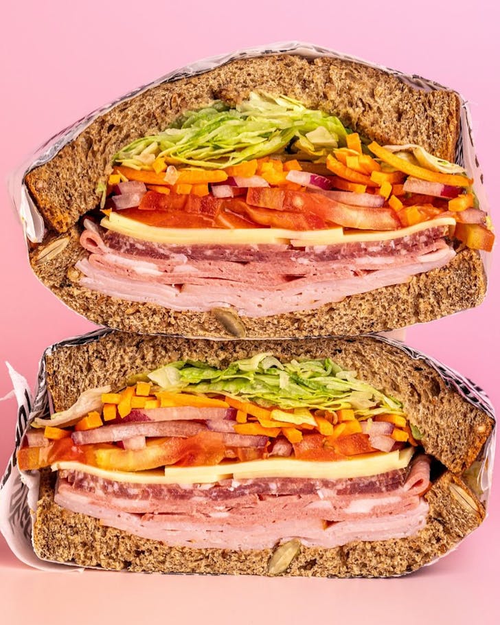 A sandwich from Angelo Street Market filled with sliced meats and salad