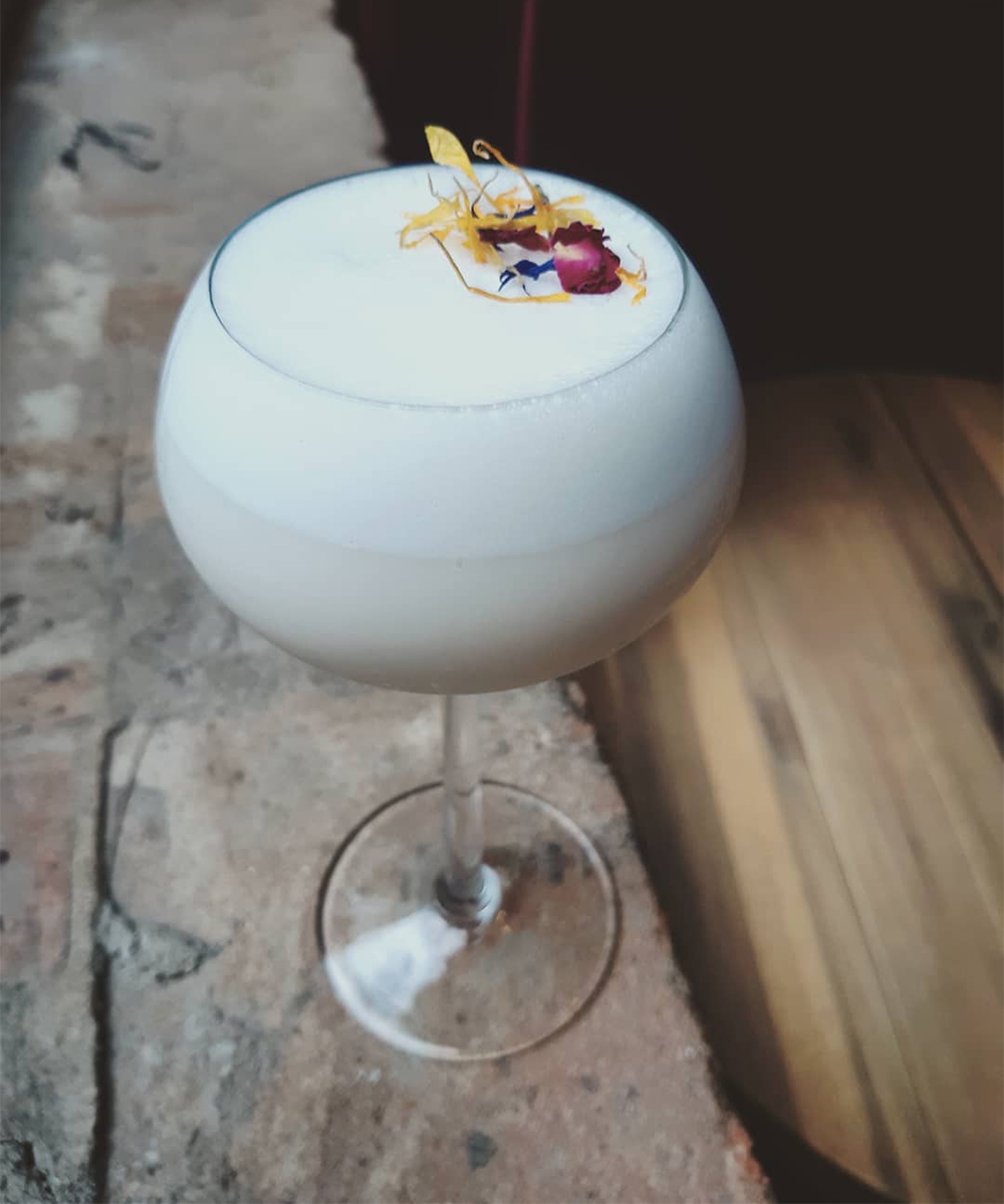 A white cocktail topped with flowers