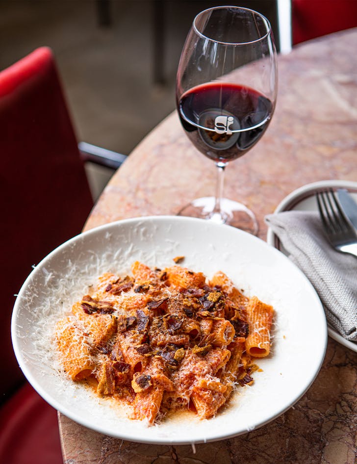 a bowl of pasta and a glass of wine