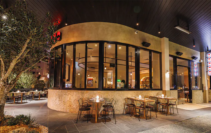 front facade of sasso, with windows looking in and tables outside