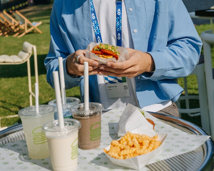person holding shake shack burger at australian open pop up 