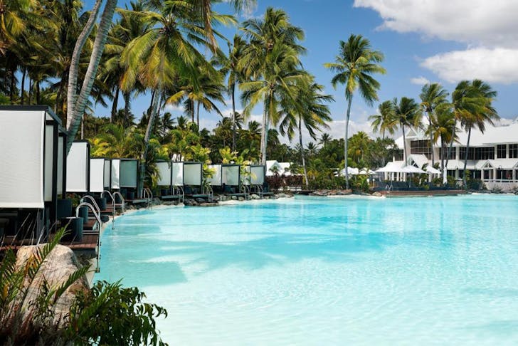 a pool lined with cabanas at Sheraton Grand Mirage Port Douglas