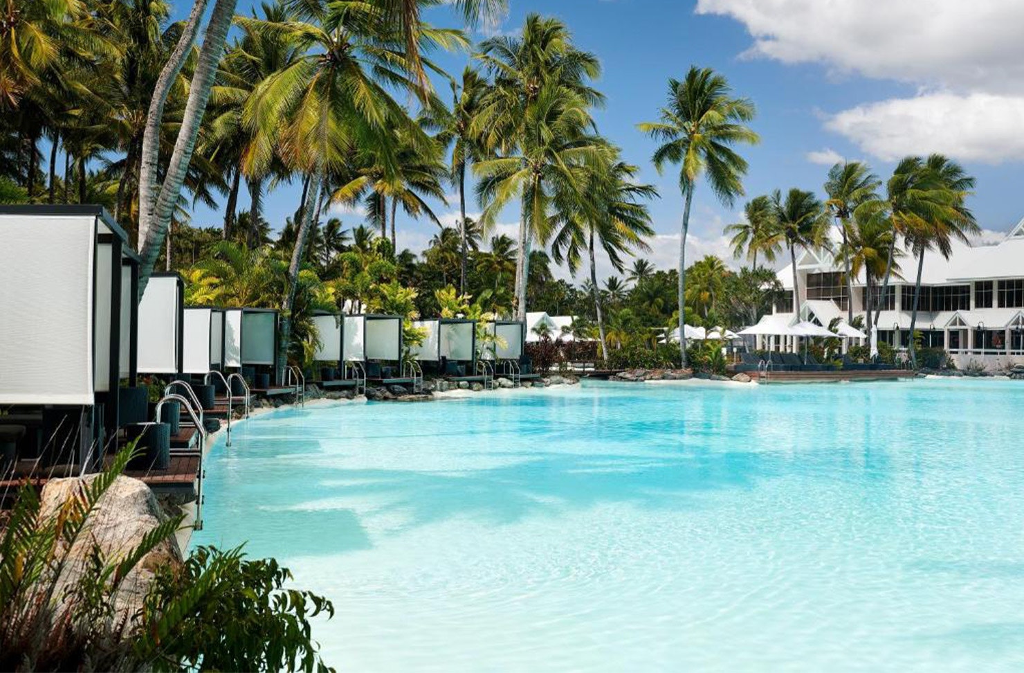 a pool lined with cabanas at Sheraton Grand Mirage Port Douglas