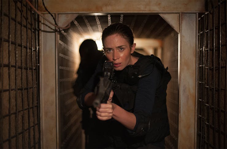 Emily Blunt advances down a corridor with gun in hand in a scene from John Wick