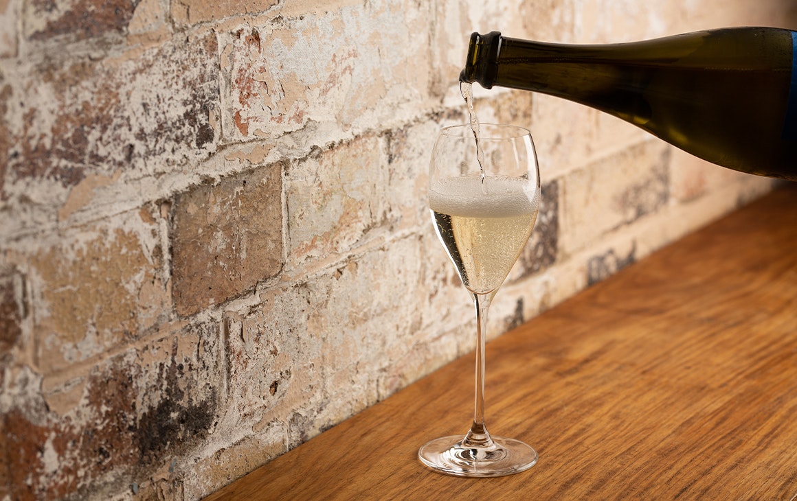 a glass of prosecco being poured