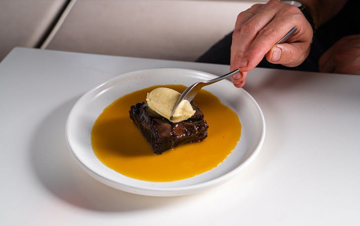 a dessert of brownie with ice cream and caramel sauce