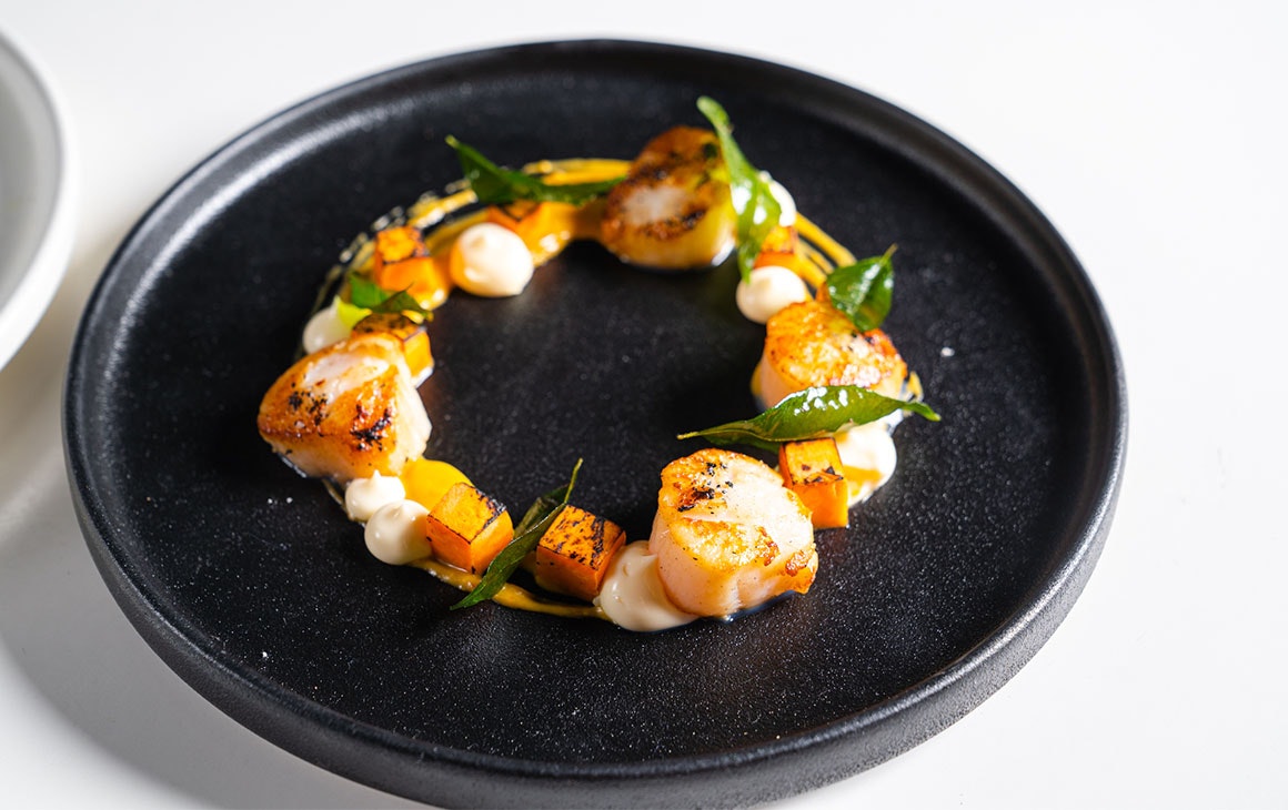 a scallop and vegetable dish arranged in a ring