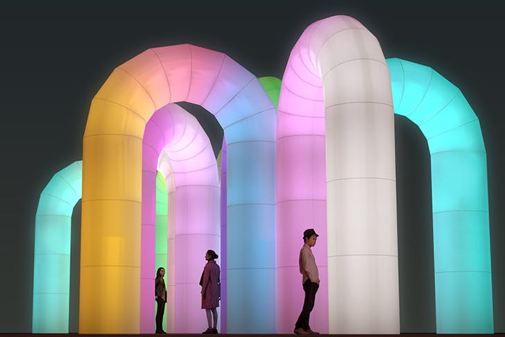 Several large inflatable arches lit up by neons. 