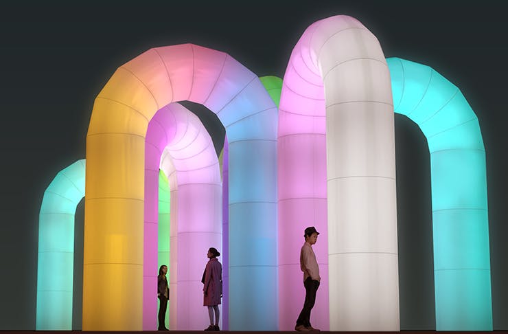 Several large inflatable arches lit up by neons. 
