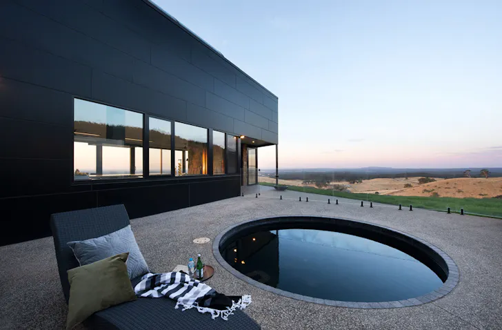A plunge pool on a deck overlooking a stunning view at Sky High Airbnb one of the best accommodation options in Daylesford