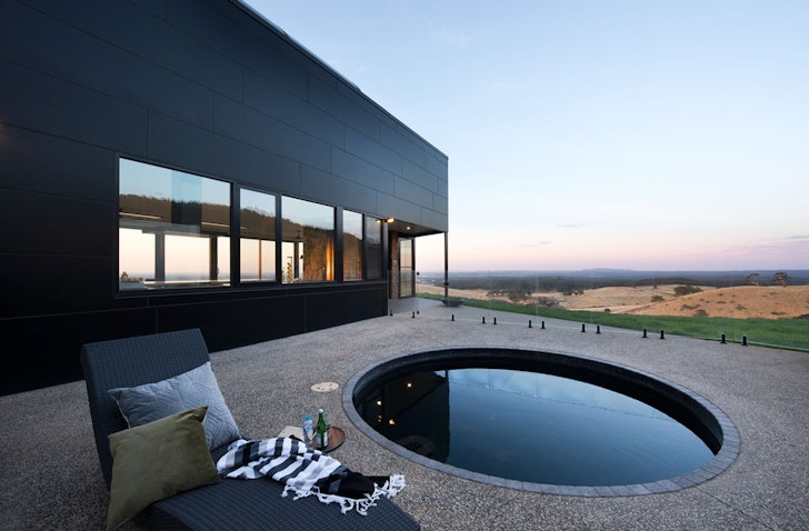 A plunge pool on a deck overlooking a stunning view at Sky High Airbnb one of the best accommodation options in Daylesford