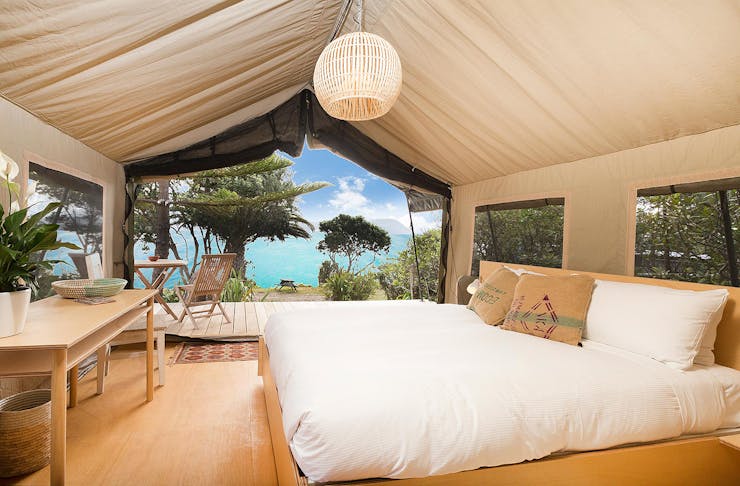 Glamping tent at slipper island looks out over impossibly blue sea.